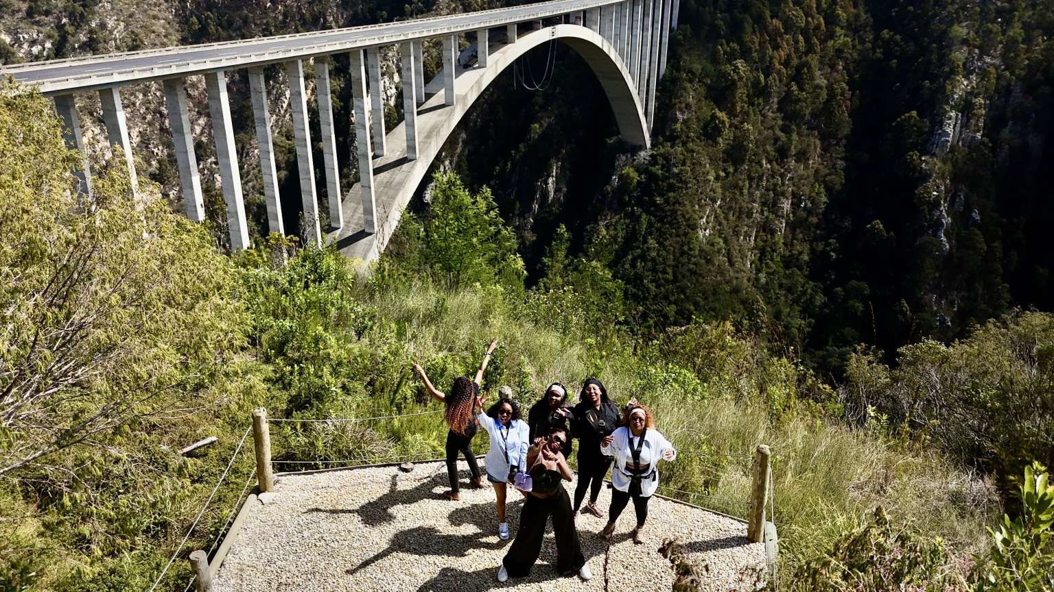 Visitors walking the path down towards Bloukrans Bridge with the arch behind them