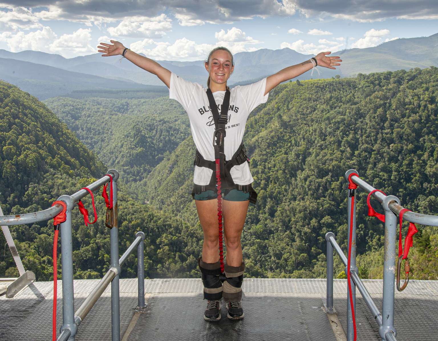 Jumper with arms outstretched on the Bloukrans Bridge platform, ankles bound and ready to jump