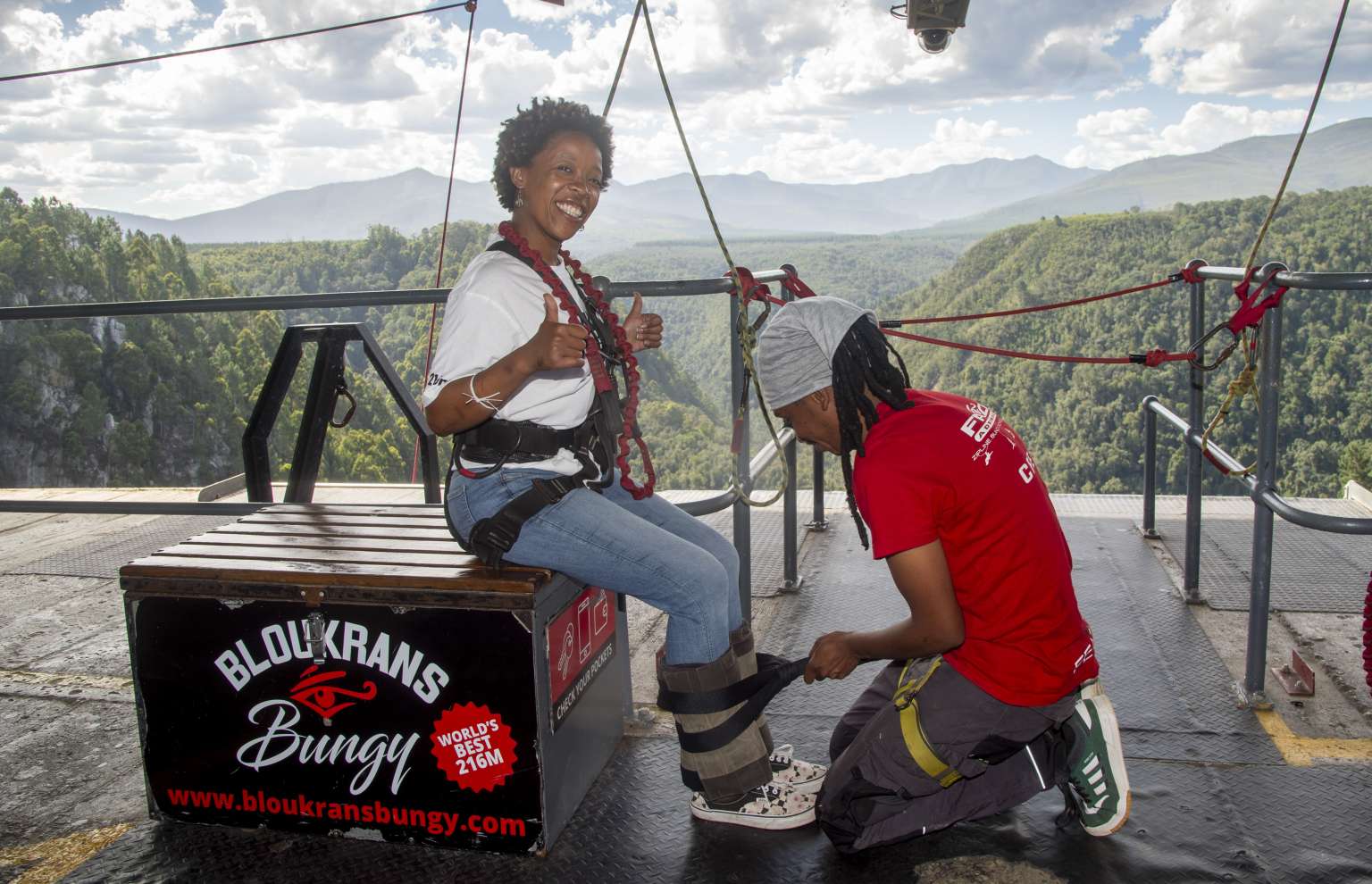 Face Adrenalin crew member fitting a jumper's ankle harness on the Bloukrans Bridge platform